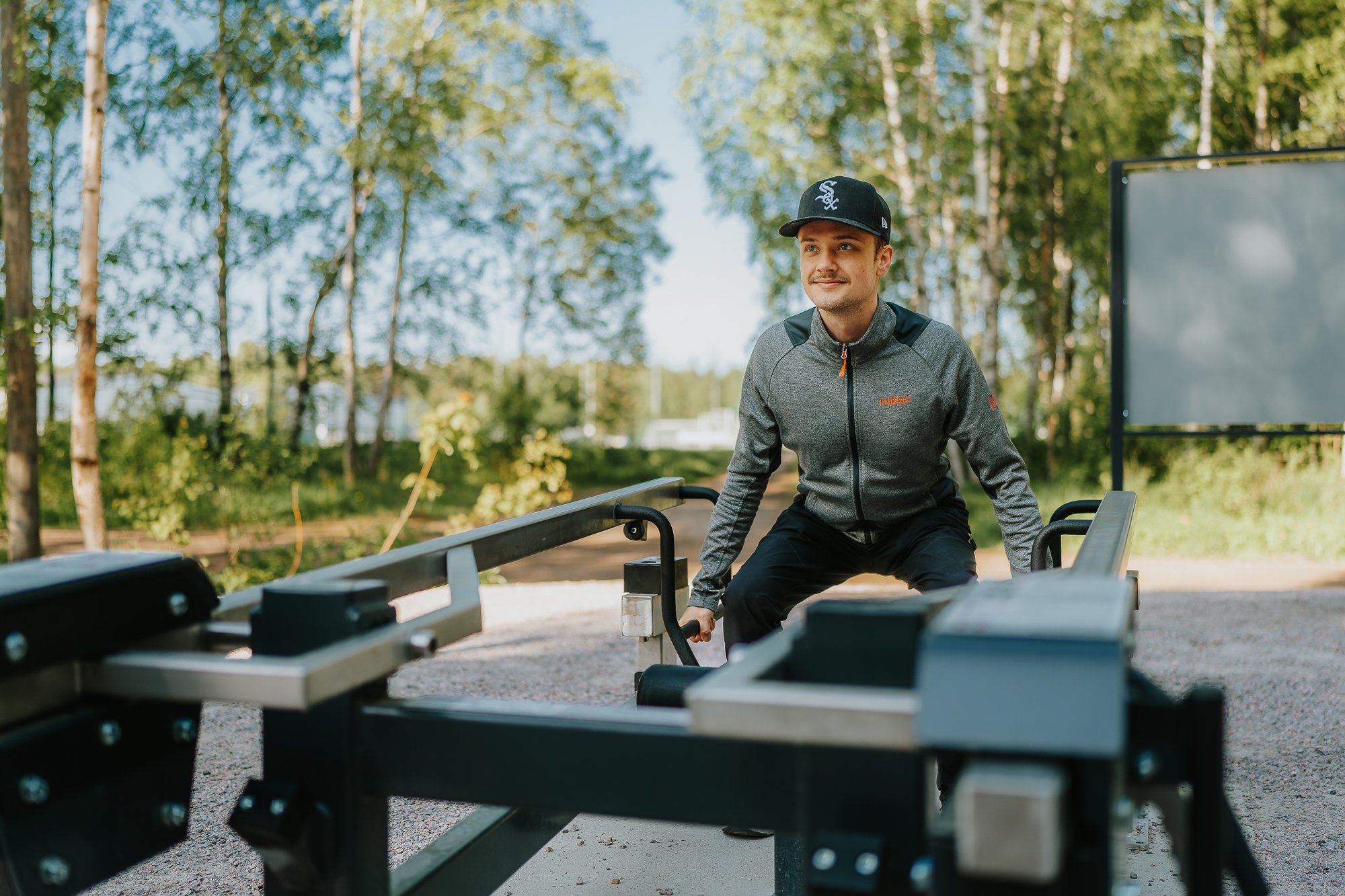 A man doing hack squat at an outdoor gym