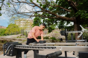 A man adjusting weight unit at outdoor gym in Katri Valan puisto park in Helsinki