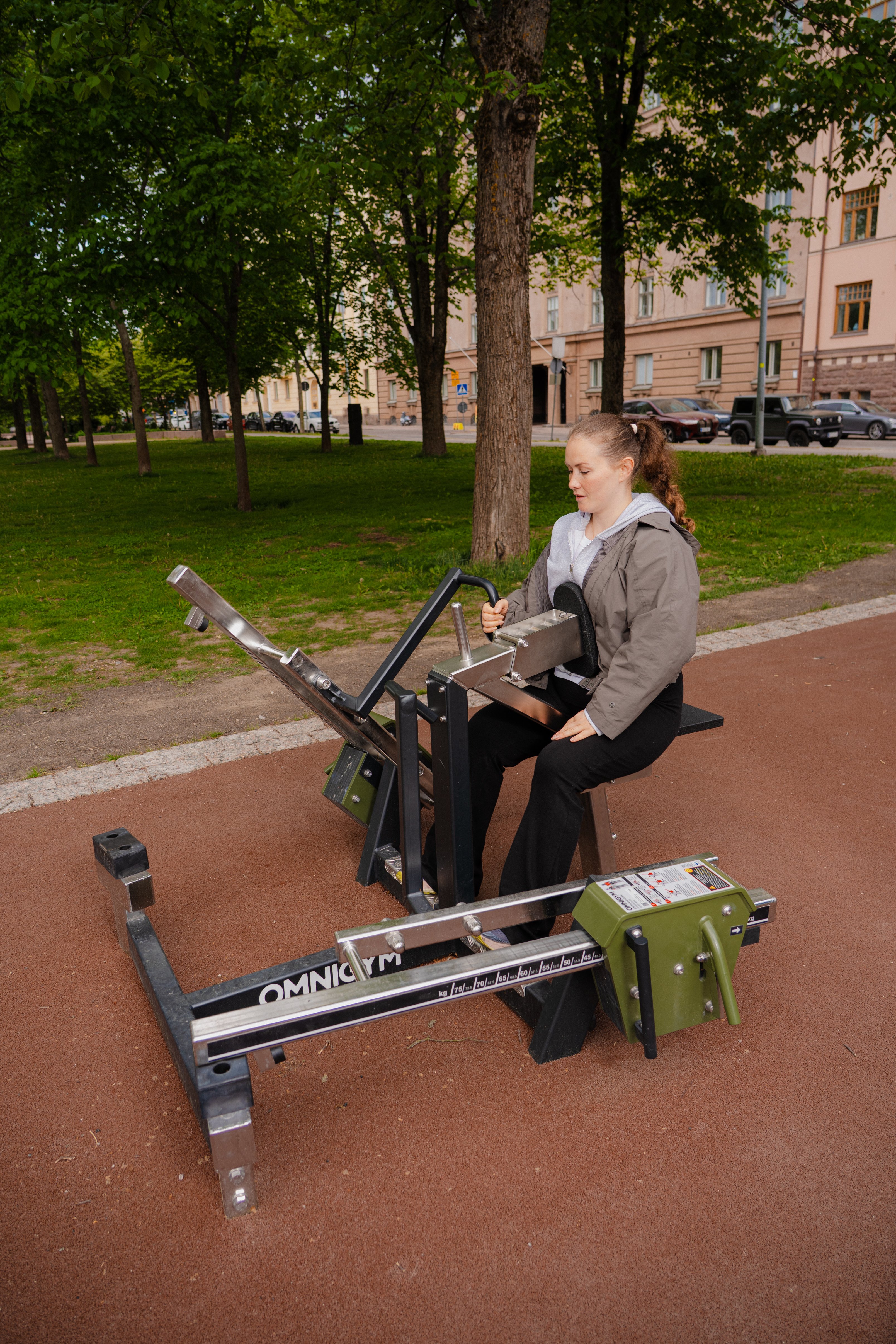 A female doing one hand row at an outdoor gym