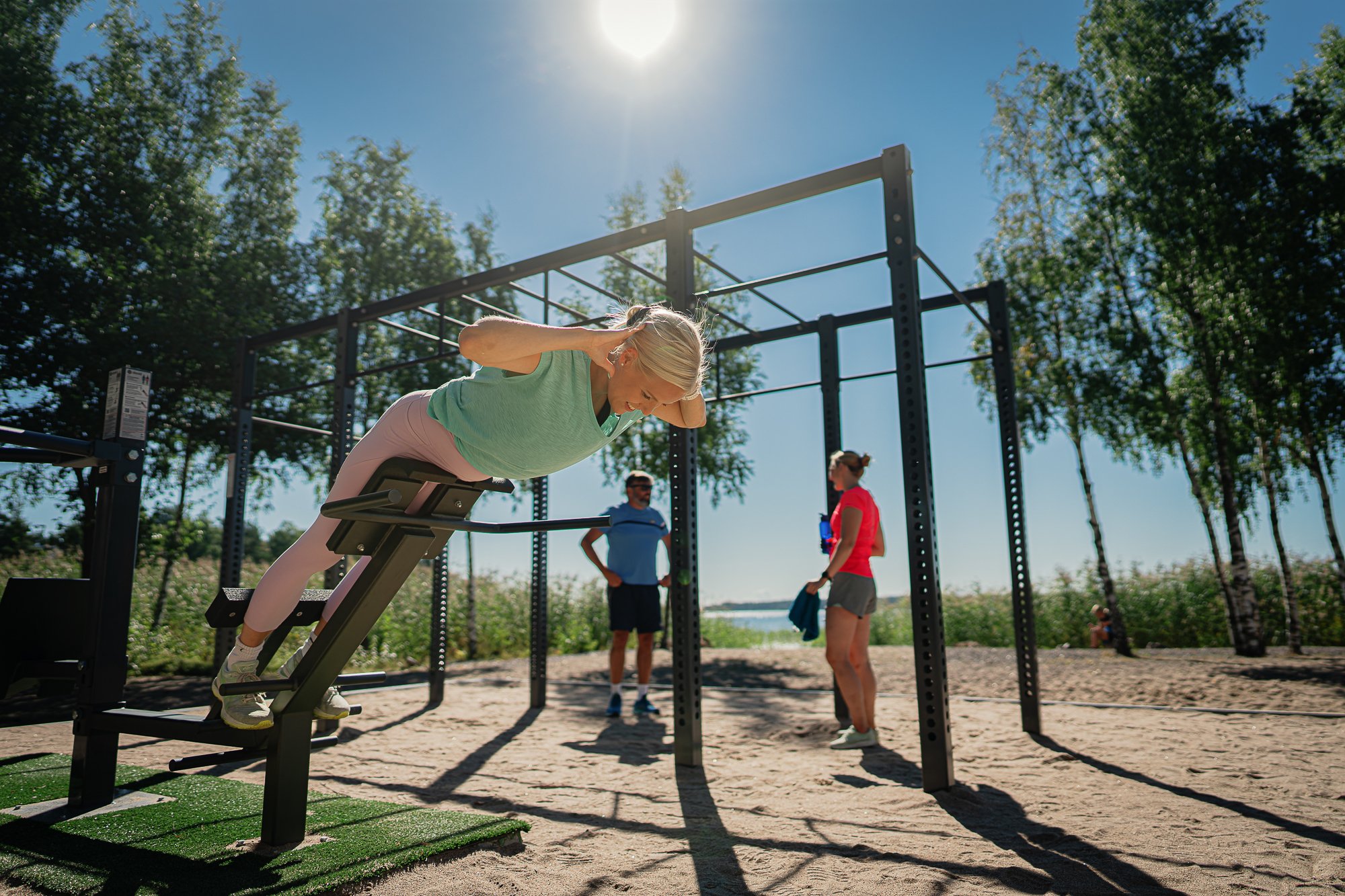 People working out at an outdoorgym by the beach