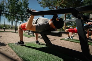 A man working out at an outdoor gym by a beach