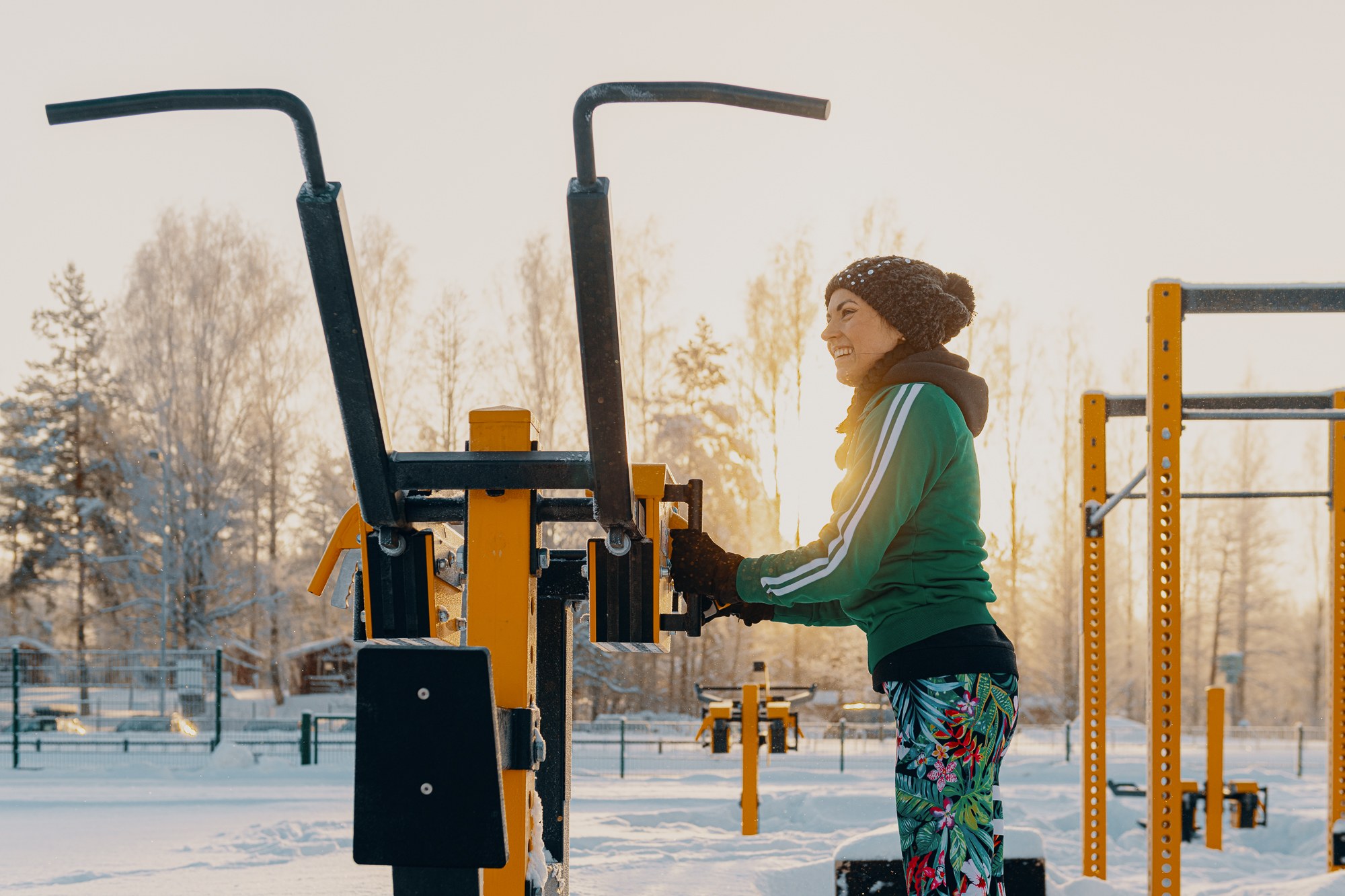 woman adjusting the weight of an outdoor gym machine