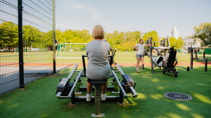 A woman doing row exercise at an outdoor gym