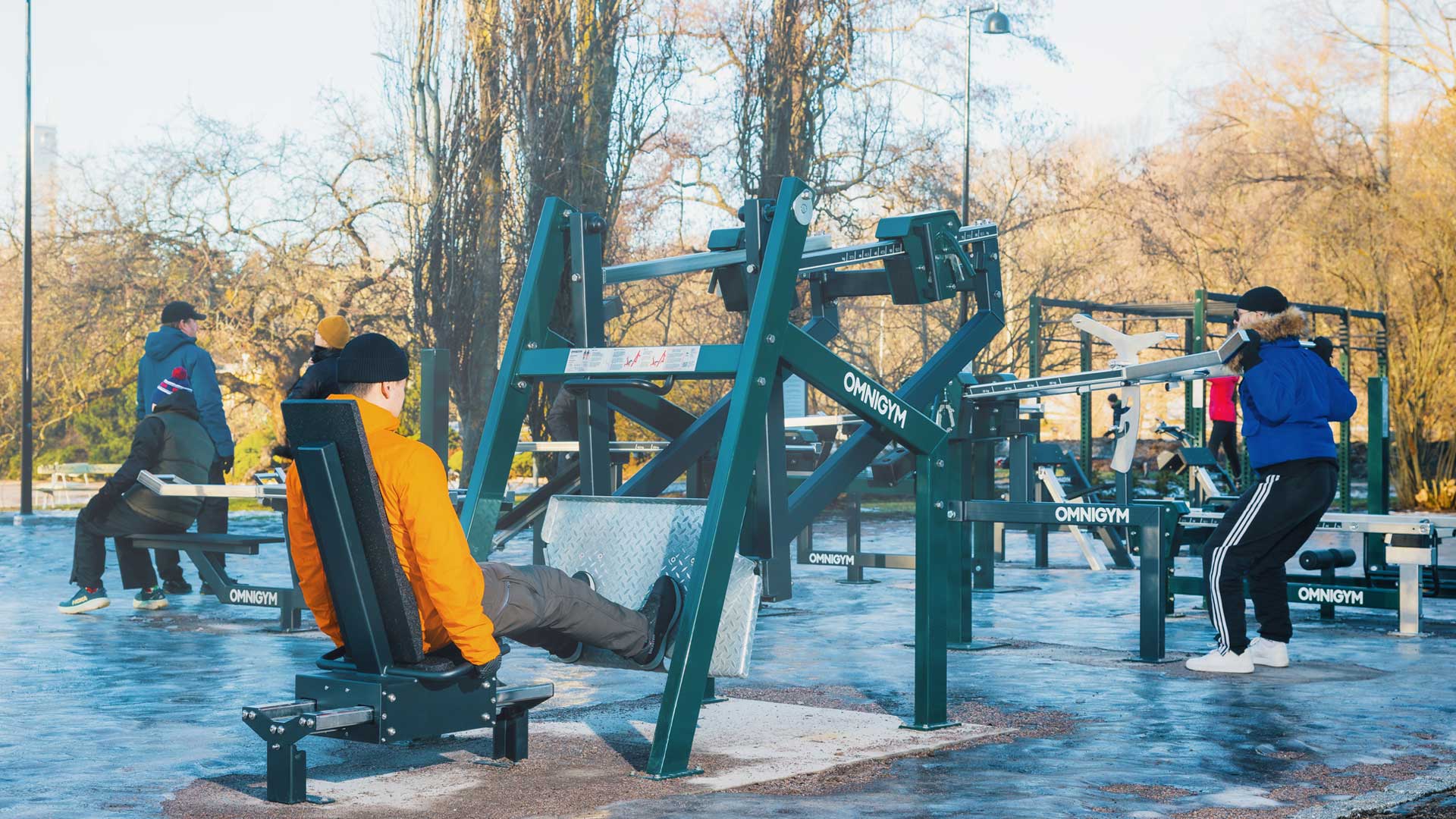 Groupe de personnes s’entraînant en extérieur en hiver en Europe du Nord avec des équipements de fitness en plein air Omnigym Groupe de personnes s’entraînant en extérieur en hiver en Europe du Nord avec des équipements de fitness en plein air Omnigym