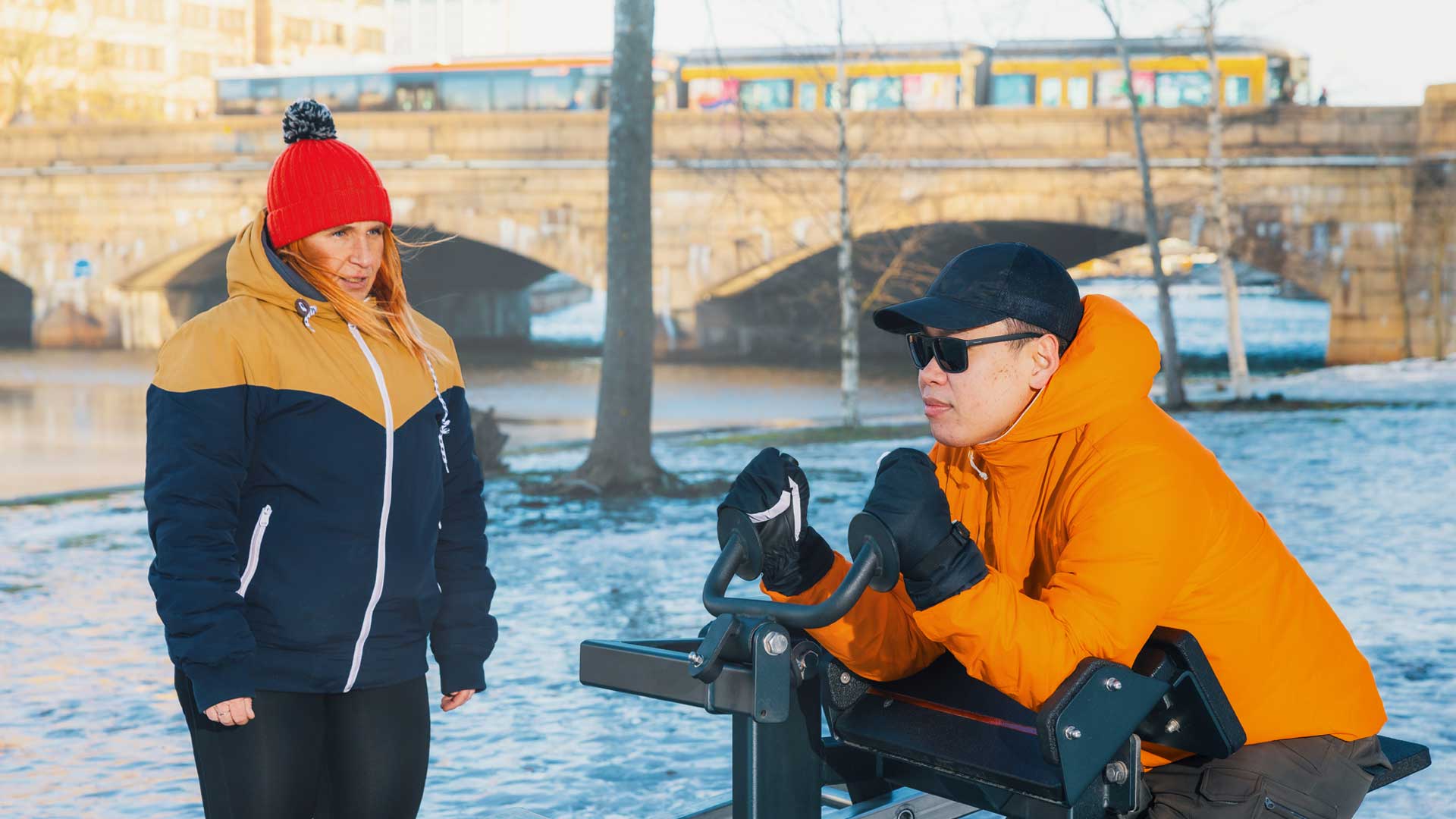 Deux personnes s’entraînant en extérieur en hiver à Helsinki avec des équipements de fitness en plein air Omnigym Deux personnes s’entraînant en extérieur en hiver à Helsinki avec des équipements de fitness en plein air Omnigym